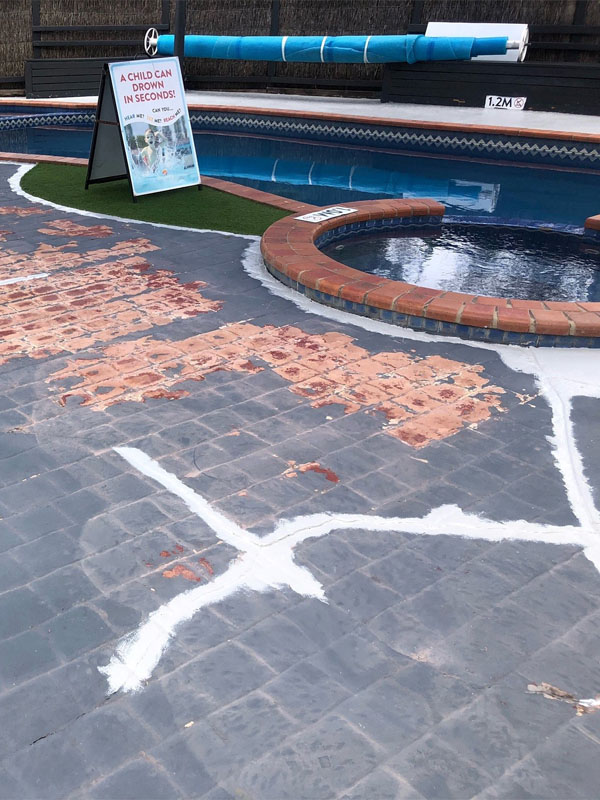 Before: pool surround pavers with patchy paint and white filler