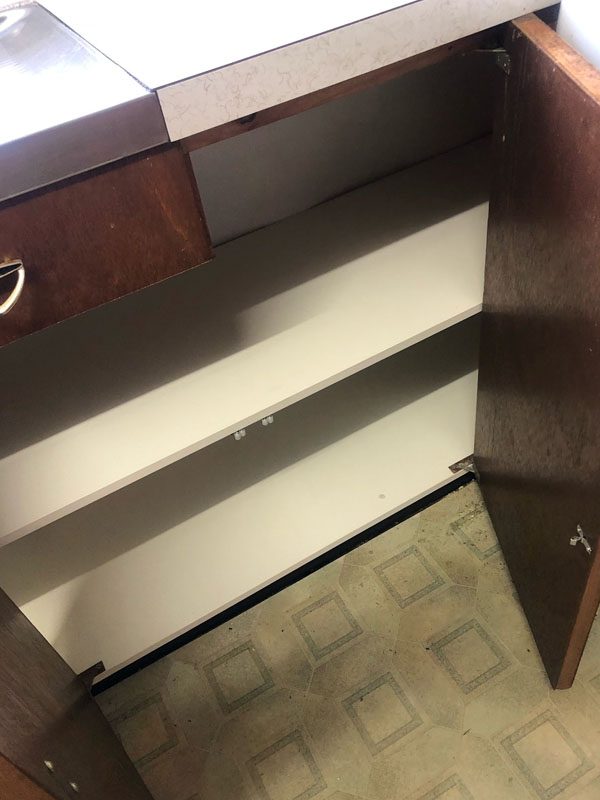 After: the same cupboard with clean white shelves and base