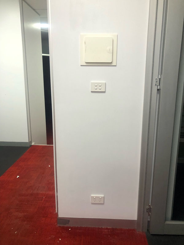 Hallway corner with white painted walls and red carpet