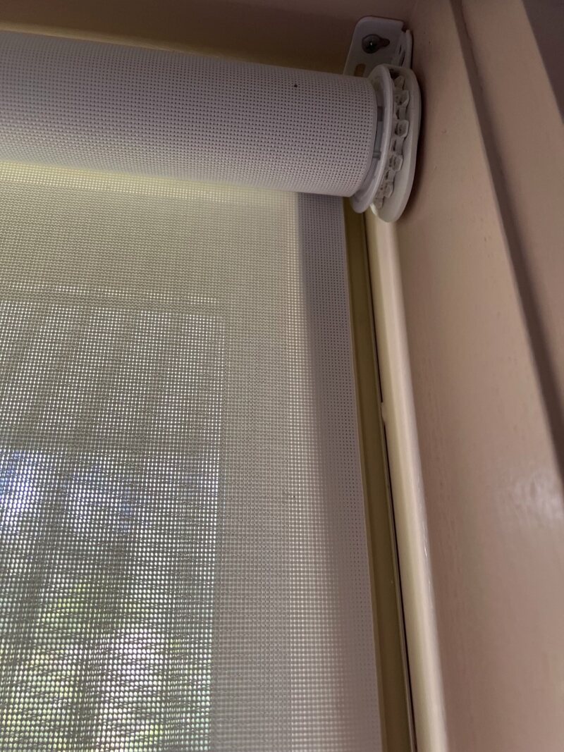 Close-up of a mesh roller blind fitted inside a window frame