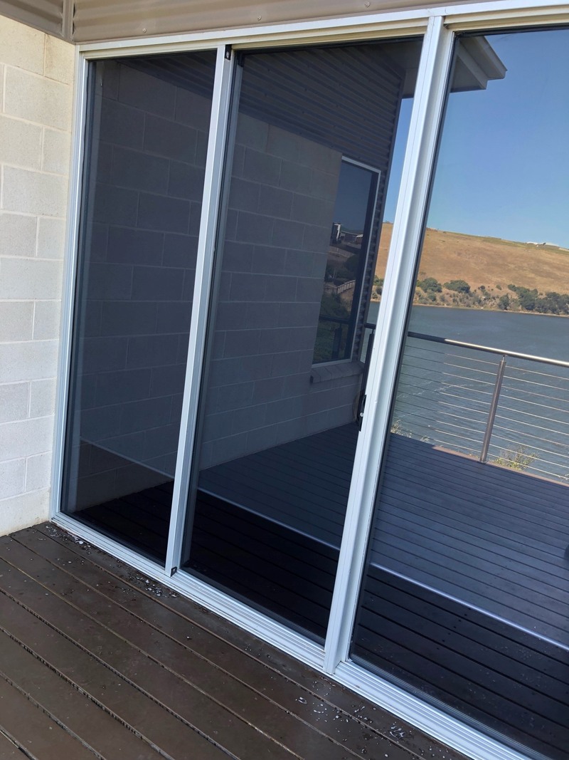 Sliding glass doors opening onto a dark-stained timber deck