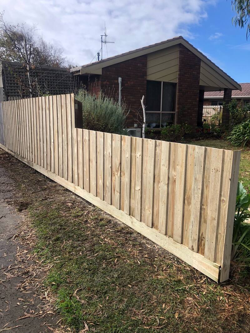 New timber paling fence along the side of a brick house